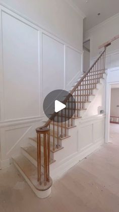 an empty room with white walls and wooden stairs