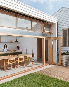 a woman and her child are standing in the open living area of a modern house