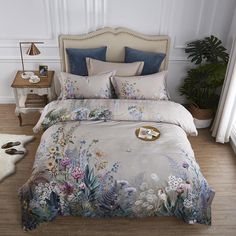 a bedroom with a bed covered in a floral comforter and matching pillowcases