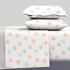 two pillows are stacked on top of each other next to a box with polka dots