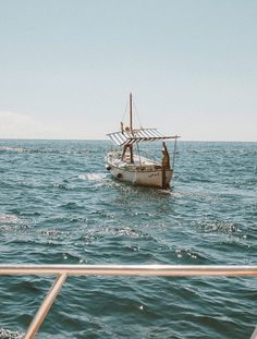 two people on a boat in the middle of the ocean with no one around them