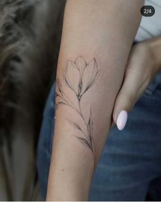 a woman's arm with a flower tattoo on the left side of her arm