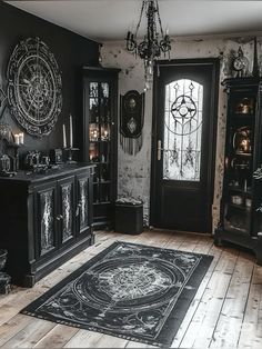 a black and white room with an ornate rug on the floor, chandelier and cabinet