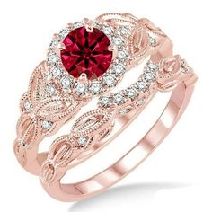 a ring with a red stone in the center and white diamonds around it, on top of