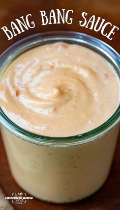 a jar filled with sauce sitting on top of a wooden table