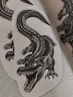 three black and white dragon tattoo designs on the back of a person's arm