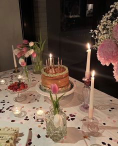 a table topped with a cake and lots of candles