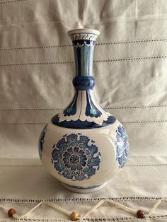 a blue and white vase sitting on top of a table next to some stringing