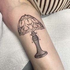 a tattoo on the arm of a woman with a mushroom lamp in it's center