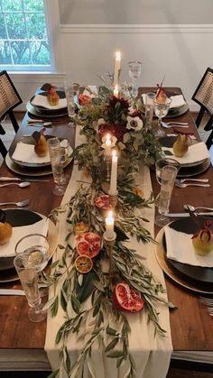 the table is set with fruit and candles for an elegant dinner party or special occasion