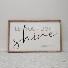 a wooden sign that says let your light shine with the word above it in black and white