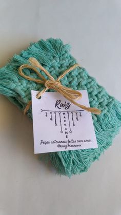 the tag is attached to a green knitted item with twine and string on it