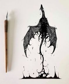 a pen and ink drawing of a dragon on a white paper with a wooden sticker next to it