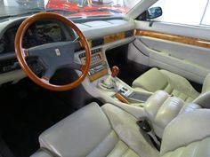 an interior view of a car with white leather and wood trim