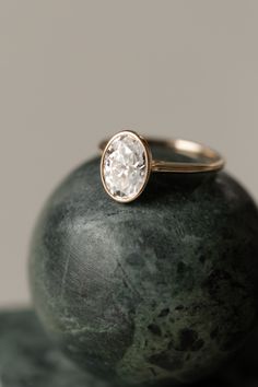 a diamond ring sitting on top of a rock