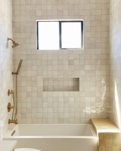 a bathroom with a toilet, bathtub and window