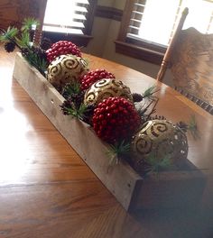 a wooden box filled with ornaments sitting on top of a table next to a window