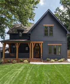 a blue house is shown in the middle of a green yard with trees and grass