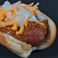 a hot dog covered in cheese and chili