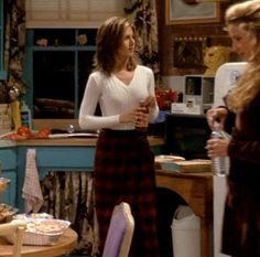 two women standing in a kitchen talking to each other