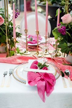 the table is set with pink flowers and candles