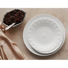 an empty white plate next to a bowl and spoon