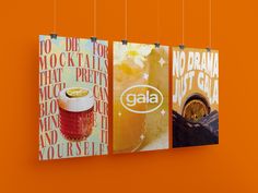 three posters hanging from strings on an orange wall, each with a different type of drink