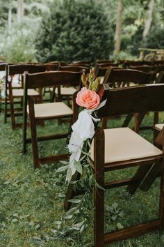 an outdoor ceremony with wooden chairs and flowers