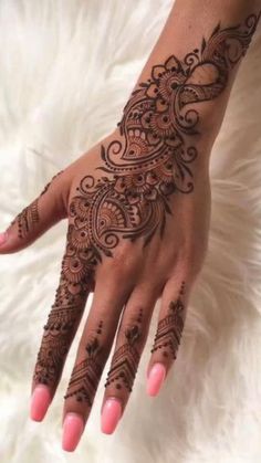 a woman's hand with henna tattoos on it