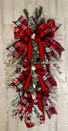 a red and black plaid christmas wreath with pine cones