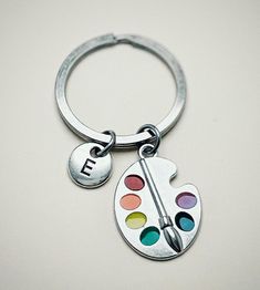 a close up of a key chain with a paint palette on it