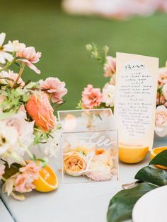 the table is set with flowers and cards for guests to write their names on them