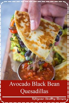 a person dipping salsa into a tortilla that is on a wooden platter