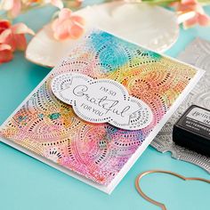 a close up of a greeting card on a table with flowers and crafting supplies