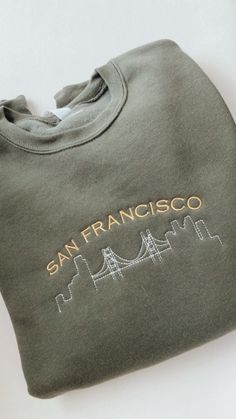 Sweatshirts are unisex sizing. Relaxed fit, true to size. If you want an oversized look, go two sizes up from your normal size. Perfect cozy gift for yourself or a special person in your life. Minimalistic approach with a modern design of The Golden Gate Bridge that will surely make a bold statement. This embroidered sweatshirt will be the only SF sweatshirt you'll need. Features: -Retail fit -Dropped shoulders -Side seamed -Rib knit cuffs and hem -7-ounce, 52/48 Airlume combed and ring spun cot Casual Sweatshirt With Embroidered Graphics, Casual Embroidered Hoodie Sweatshirt, Trendy Streetwear Sweatshirt With Custom Embroidery, Cute Custom Embroidered Sweatshirt For Streetwear, Oversized Casual Sweatshirt With Embroidered Text, Cozy Gift, Embroidered Sweater, Embroidery Monogram, Chanel Deauville Tote Bag