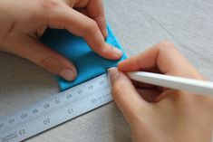 someone is using a ruler to measure the fabric