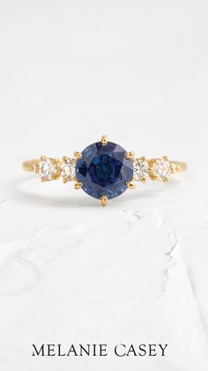 a blue sapphire and diamond ring with the words melane casey written on it in gold