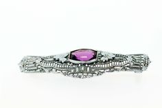 This brooch is made in 10K white gold and has beautiful engraved detail and filigree. In the center is a bezel set amethyst that has milgrain accents around it, with detailed engraved leaves on either side.The brooch measures 49.42mm wide, 18.42mm long, and 5.13mm tall. --Please reference our policy for more details-- For International orders, please provide a phone number for shipping purposes. Just place a note in the comment box during check out.Thank you.** C8830 GVVC Elegant Purple Gemstone Brooches, Elegant Amethyst Brooches For Wedding, Purple Amethyst Brooches For Wedding, Elegant Purple Brooches For Anniversary, Silver Platinum Brooches As Gifts, Classic Platinum Brooches As Gift, Platinum Silver Brooches As Gifts, Classic Platinum Brooch As A Gift, Art Deco Platinum Brooches As Gift