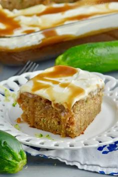 a piece of cake on a plate with icing and cucumbers in the background