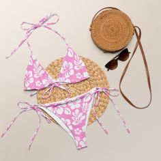 Indulge in the luxurious and exclusive style of our White Hawaiian Flowers on Pink String Bikini. This beautiful string bikini set is not only comfortable, but it also offers double-layering and UPF 50+ protection. Customize the straps to your liking and get ready to turn heads at the beach! Made from soft recycled polyester, this bikini is both stylish and sustainable. • Soft and stretchy material with UPF 50+• Sizes up to 6XL• Bikini top comes with removable padding for comfort• Multiple ways Adjustable Swimwear For Beach Party Vacation, Adjustable Swimwear For Pool Vacation, Beachy String Swimwear For Beach, Adjustable Swimwear For Vacation, Beachy String Swimwear For Beach Season, String Swimwear For Beach Season Vacation, String Swimwear For Beach Vacation, String Swimwear For Vacation And Beach Season, Adjustable Swimwear For Beach Vacation