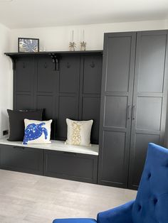 a blue chair and some black cabinets in a room