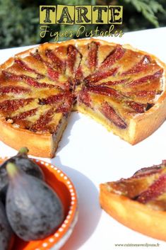 a tarte is cut into slices and placed on a plate next to some figs