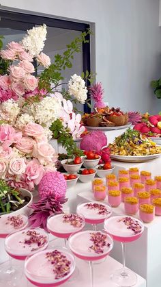 a table filled with desserts and flowers on top of it