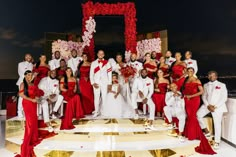 a group of people in red and white outfits posing for a photo on a stage