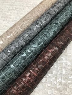 four different colors of leather on top of each other with water drops all over them