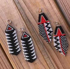 three pairs of beaded earrings sitting on top of a wooden table next to each other