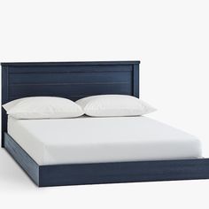 a bed with white pillows and blue headboard