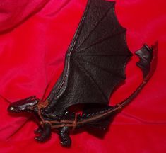 a black dragon figurine sitting on top of a red cloth