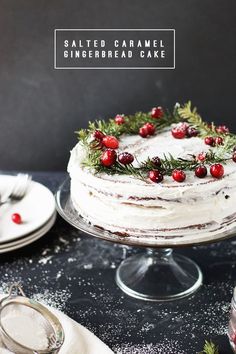 a cake with white frosting and cranberries on top sitting on a table