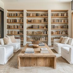 a living room filled with white couches and bookshelves